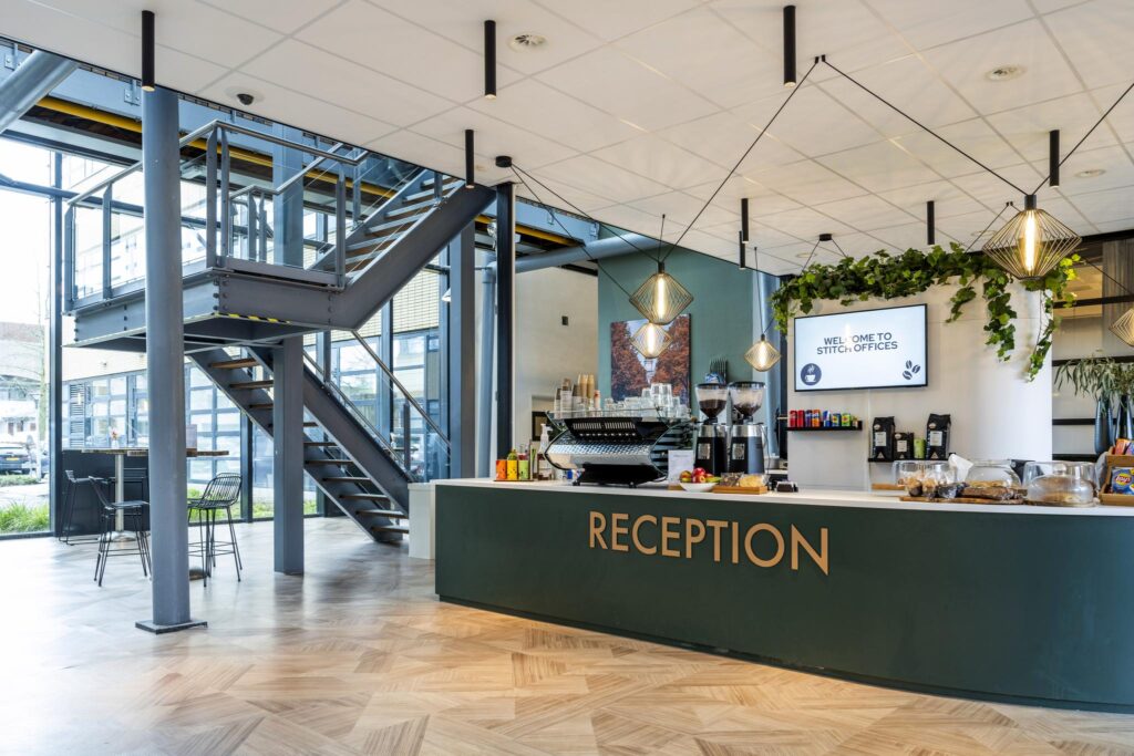 Moderne receptiebalie met koffiecorner in de entree van Stitch Offices aan de H.J.E. Wenckebachweg.
